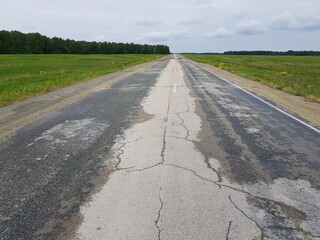 Empty asphalt road in green field