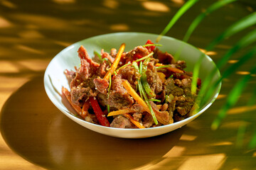 Fried lamb with cumin and vegetables in a white plate. Chinese cuisine.