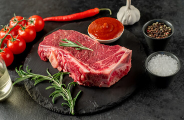 Raw marbled beef New York steak with spices on a stone background