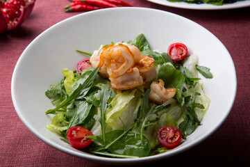 Bowl of green salad with grilled shrimps served on a table