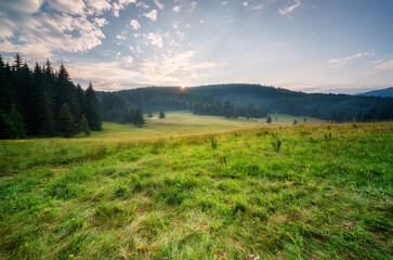 View of last sunlight over picturesque mountain meadow