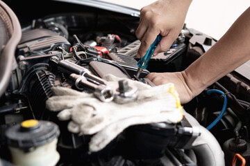 Car technician man use screwdriver remove bolt in engine room service and maintenance concept