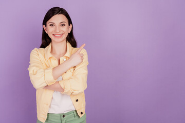 Fototapeta premium Portrait of charming adviser woman direct finger empty space on violet background