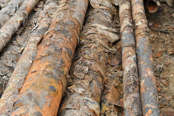 Many used rusty metal pipes taken out of the ground. Selective focus. 