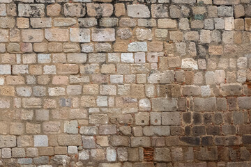 Architecture textures, detailed and rustic of irregular paired masonry granite mix with ceramic clay brick, traditional spanish granite wall
