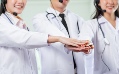 Banner of Selective focus and close up doctors hands wearing white gown with stethoscope, headsets and put together with unity power to show telemedicine and healthcare concept.
