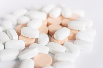 White and colored pills on a white background. Oblong and round pills close-up. Healthcare and medicine.