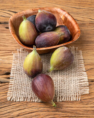 Figs in a bowl over wooden table. Short depth of field