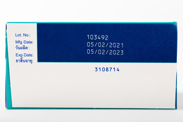 Instruction of lot number, manufacturing date, and expiry date label of a product with Thai language on the bottom lid of the package with isolated white background and copy space.