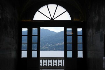 scenic Italian Lake front view from frame open  window and twilight balcony, villa Carlotta, lake Como