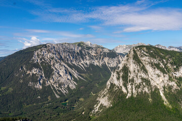 A panoramic view on the Alpine mountain chains in Austria, Hochschwab region. The slopes are partially overgrown with small bushes, higher parts baren. Clear and sunny day. Serenity. Hiking in Alps