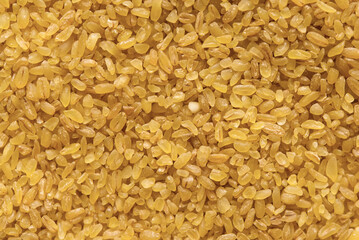 Bulgur - cooked and dried wheat groats, food background	
