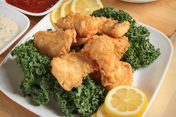 deep fried halibut fish on garnished plate with dipping sauces