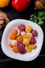 boiled dumplings assorted, different colors ravioli on wooden table