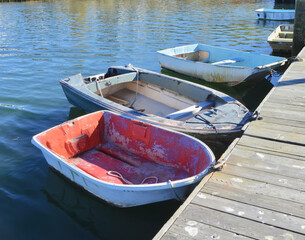 Old work dinghies tied to a dock.  Setauket Harbor, New York.  Copy space.