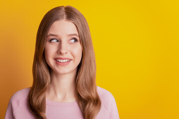 Obraz premium Photo of dreamy inspired girl beaming smile look empty space on yellow background