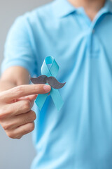 November Prostate Cancer Awareness month, Man holding Blue Ribbon with mustache for supporting...