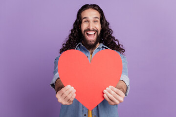 Closeup of happy smiling guy hold heart figure excited face