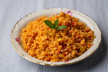Traditional turkish bulgur pilaf with tomato sause in plate (Turkish name; meyhane pilavi)