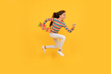 Fototapeta na wymiar happy energetic teen girl skateboarder jumping with penny board skateboard, pennyboard