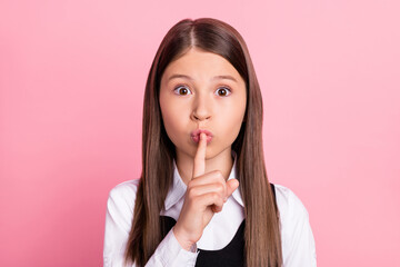 Photo of young little girl cover lips finger shh keep secret confidential shut up isolated over pink color background
