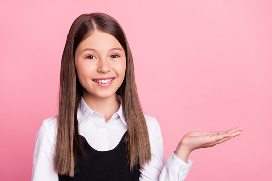 Photo of young school girl happy positive smile pesent product ad suggest sale isolated over pink color background