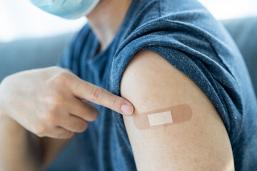 Man pointing finger at vaccine injection point.