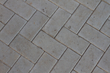 Gray paving slabs. Background. Grey brick paving stones on a sidewalk.