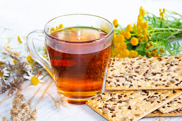 Tea with cookies. Glass cup with hot tea, cookies and flowers.