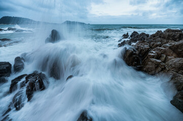 Powerful big wave hitting and splashing on the rock of coastline