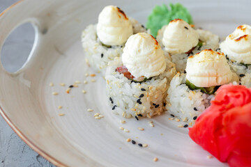 Japanese sushi with sesame seeds and cream icing on gray background