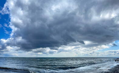 Wild coast on cape Kolka with thunderstorm clouds after a storm on the shore of the Baltic Sea. Cape Kolka - the meeting place of the Baltic sea and the Gulf of Riga, Latvia.