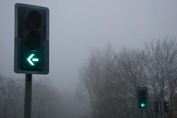 Traffic lights in fog and mist, hazardous and dangerous driving conditions.