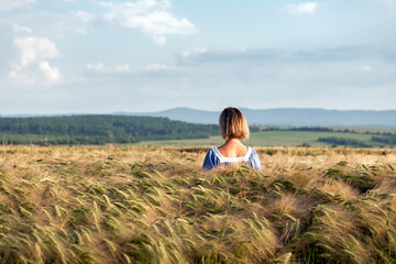 Naklejka na ściany i meble Woman in a wheat field