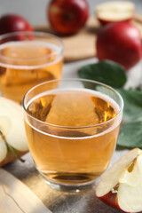 Delicious cider and ripe apple on table, closeup