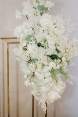 Wedding photo zone decorated by white flowers and green leafs