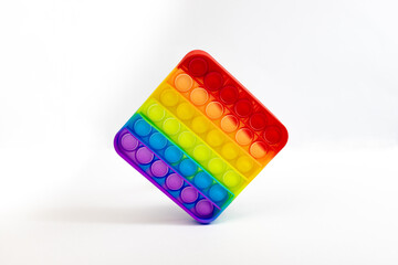 Pop It Simple Dimple - silicone sensory anti-stress. Toy colorful rainbow game isolated on white background, copy space. Calming tools, adult stress reliever popping, trendy push bubble toys