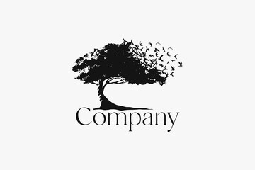 Elegant tree logo with birds flying on it.