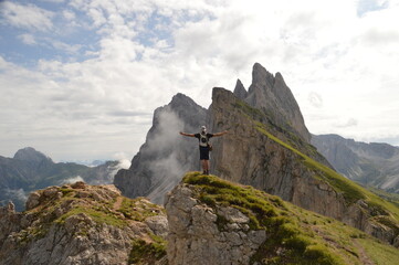 Fototapeta na wymiar Taking in the stunning mountain views from a steep ridge in the Dolomites 