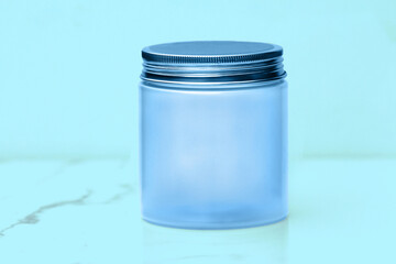 Screw top blank blue jar with a pale blue background
