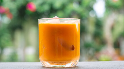 ice tea or ice thai tea in glass , fresh dessert with nature background 