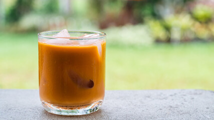 ice tea or ice thai tea in glass , fresh dessert with nature background 
