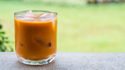 ice tea or ice thai tea in glass , fresh dessert with nature background 