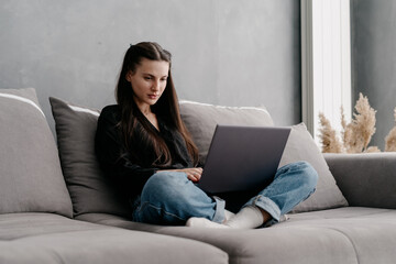 Fototapeta premium Focused young european woman using laptop computer for remote work from home