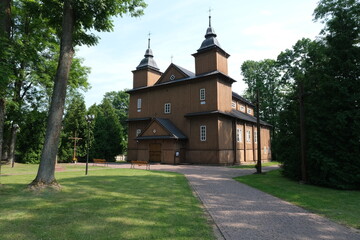 Fototapeta na wymiar Narew, Poland - July 12, 2021: Orthodox brown church. Parish of the Assumption of the Blessed Virgin Mary and St. Stanislaus the Bishop and Martyr. Summer sunny day