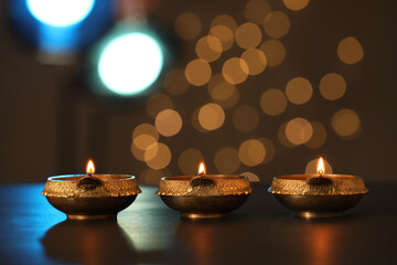 Obraz na płótnie Canvas Lit diya lamps on dark table. Diwali celebration