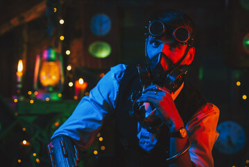Cyberpunk post-apocalypse cosplay. A man with glasses and a gas mask in a workshop with a neon light