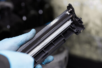 Service worker checks the primary charge roller at the laser printer cartridge. Recovering and...