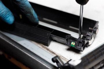 toner cartridge is disassembled with a screwdriver at a service center.
