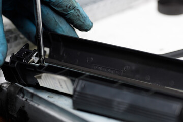 toner cartridge is disassembled with a screwdriver at a service center.